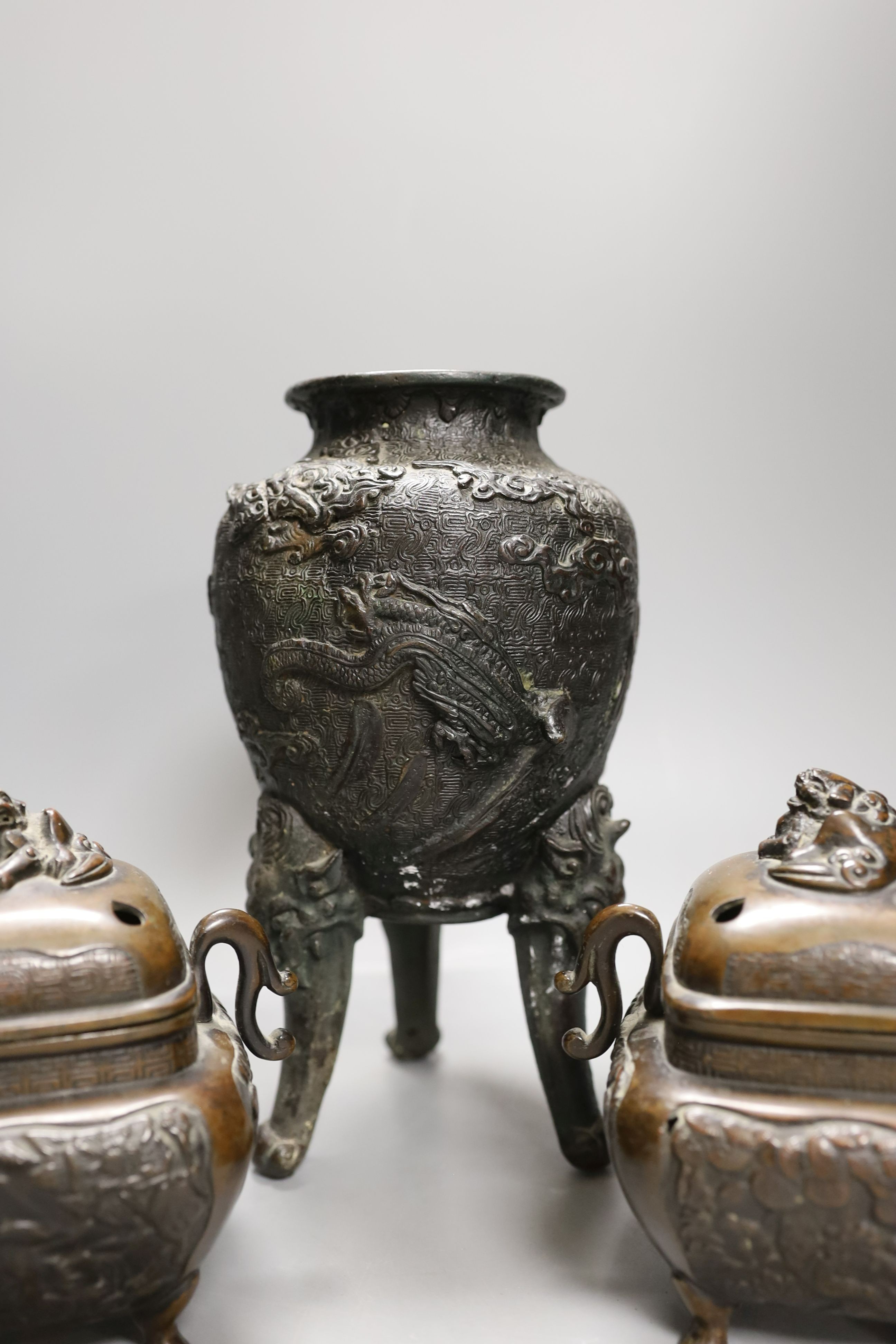 A pair of Japanese bronze censers and covers and a Japanese bronze tripod censer, 23cm tall, (3)